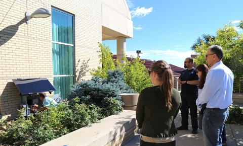 several people observe man installing solar panel at Colorado School of Mines Geology museum