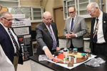 Tom Lograsso, interim CMI Director, shows samples to US Representatives visiting Ames Laboratory
