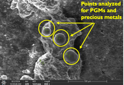 a grayscale scanning electron microscope image with text overlay to show points analyzed for platinum group metals and precious metals