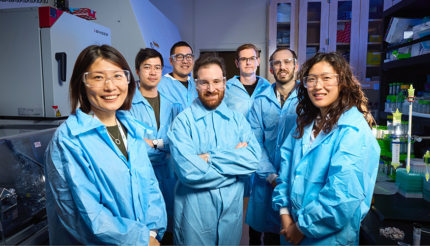 image of people wearing blue lab coats standing together