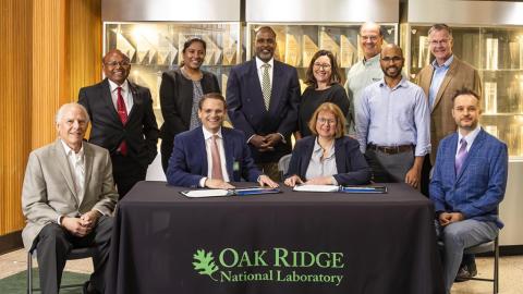 photo of a group of people: Seated, from left to right, are Bruce Moyer, ORNL corporate fellow; Hood Whitson, Element3 CEO; Cynthia Jenks, ORNL associate laboratory director for the Physical Sciences Directorate; and Wes Kowalczuk, an engineer with Element3. Standing, from left to right, are Parans Paranthaman, ORNL corporate fellow; Jayanthi Kumar, ORNL staff scientist; Reis Alsberry, ORNL commercialization manager; Jennifer Caldwell, ORNL director of technology transfer; Eugene Cochran, technology commercialization group leader; Syed Islam, ORNL staff scientist; and Mike Paulus, director of partnerships. Credit: Carlos Jones/ORNL, U.S. Dept. of Energy