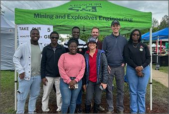 group of people standing by a green awning