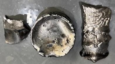 Cast neodymium metal pieces (~128 g) produced via calciothermic reduction of Na‑lean neodymium fluoride.