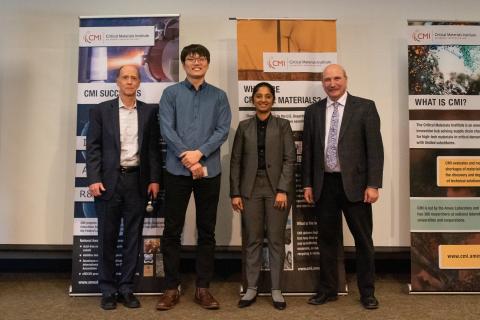 image of four people standing in front of two banners: CMI Deputy Director Rod Eggert, Colorado School of Mines, Reyixiati “Richard” Repukaiti, Idaho National Laboratory, Sangita Gayatri Kannon, Colorado School of Mines, and CMI Director Tom Lograsso, Ames National Laboratory 