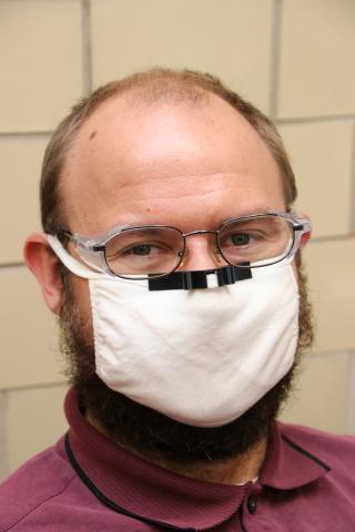 Person wearing a mask with custom nose-piece