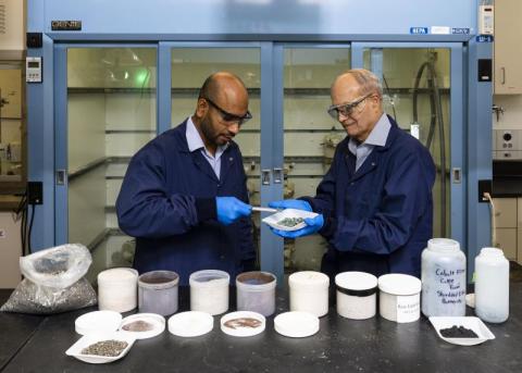 photo of two people in research laboratory looking at samples: From left, researchers Syed Islam and Ramesh Bhave discuss the nickel sulfate recovered from end-of-life lithium-ion batteries using the membrane solvent extraction process they co-invented at ORNL. Credit: Carlos Jones/ORNL, U.S. Dept. of Energy