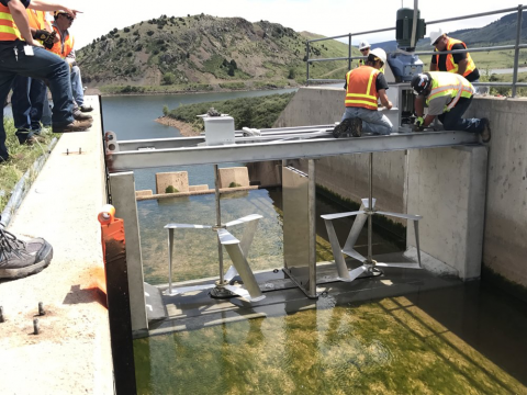 workers install aluminum-cerium turbines in water to generate electricity from moving water