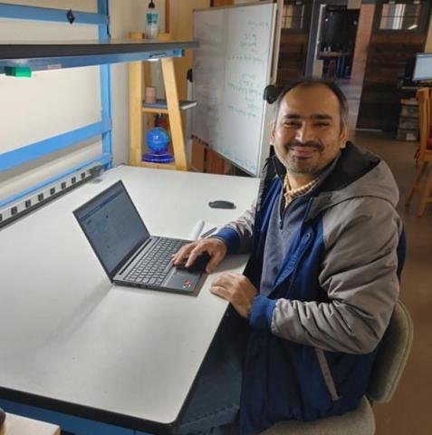 image of man sitting by a computer