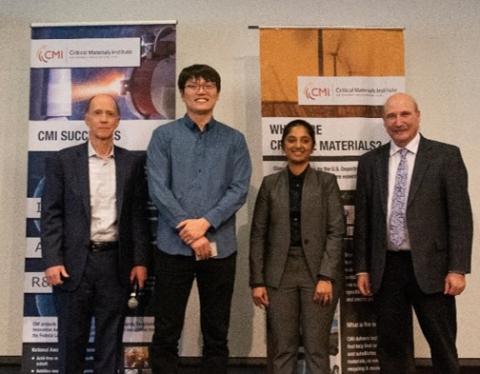 image of four people standing in front of two banners: CMI Deputy Director Rod Eggert, Colorado School of Mines, Reyixiati “Richard” Repukaiti, Idaho National Laboratory, Sangita Gayatri Kannon, Colorado School of Mines, and CMI Director Tom Lograsso, Ames National Laboratory 