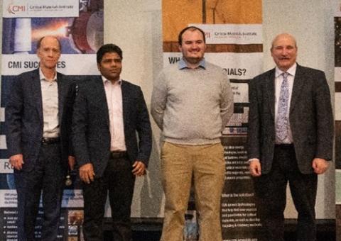 image of four people standing in front of two banners: CMI Deputy Director Rod Eggert, Colorado School of Mines, Reyixiati “Richard” Repukaiti, Idaho National Laboratory, Sangita Gayatri Kannon, Colorado School of Mines, and CMI Director Tom Lograsso, Ames National Laboratory 