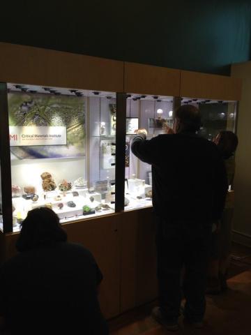 silhouettes of people against brightly lit display case