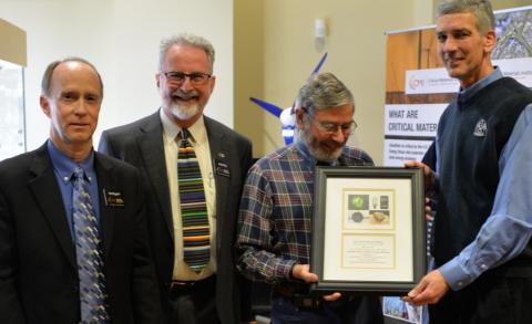 four men with plaque at opening of CMI museum exhibit