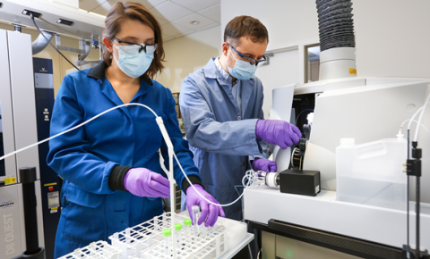 Two people work in a science laboratory: Santa Jansone-Popova (L) and Ilja Popovs quantify rare-earth element concentrations in liquid samples using spectroscopy (Courtesy Genevieve Martin/ORNL, US DOE)