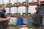 two men stand in warehouse