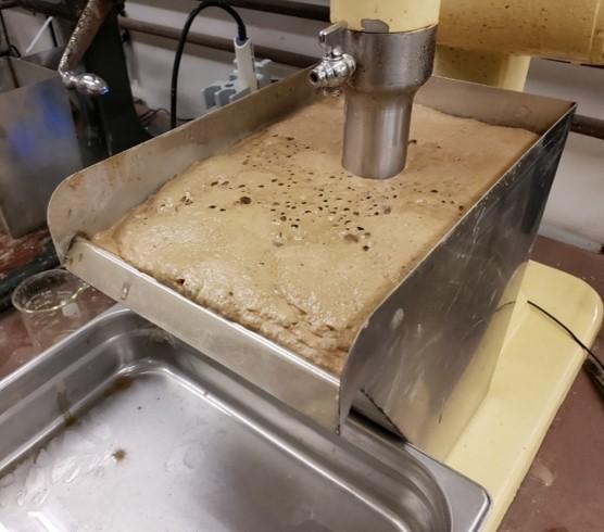 Flotation experiment, showing bastnaesite-rich froth