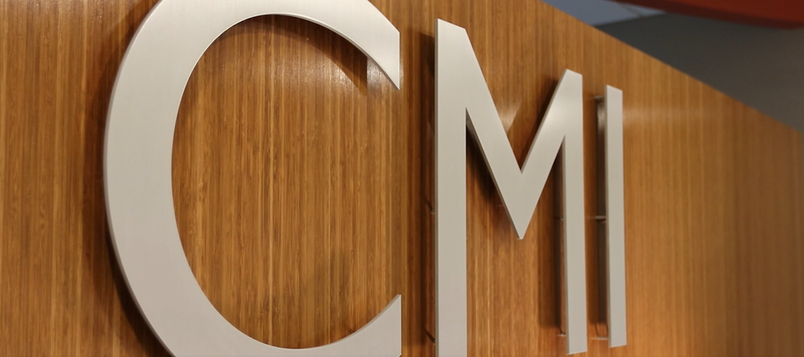 image of metal letters C M I on a brown background