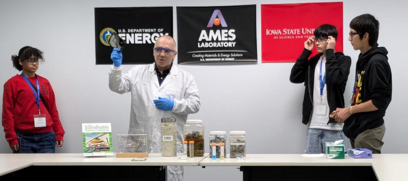 image of scientist wearing a lab coat and three students