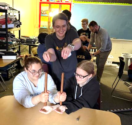person demonstrating strength of magnets in copper tubes