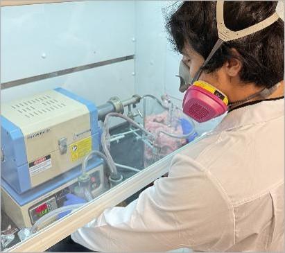 person wearing personal protective equipment uses research equipment