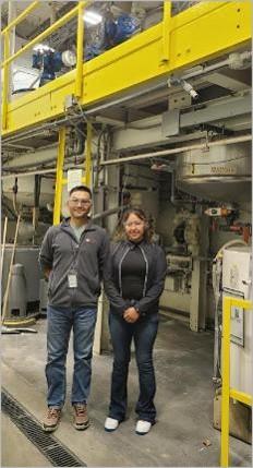 two people standing in a factory