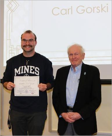 image of two people standing, one holding a certificate