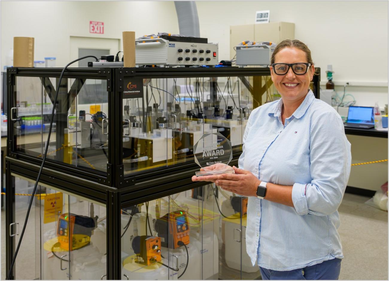 person holding an award in a research laboratory