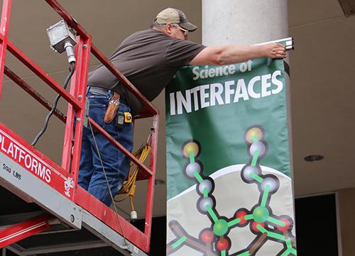 FES worker hanging a banner on building exterior