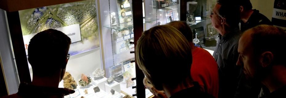 people look at CMI exhibit in a glass case