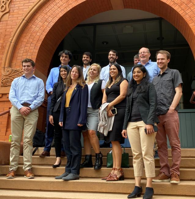 group of people standing on stairs under brick archway