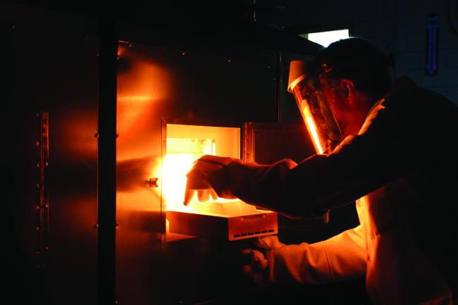 Ames Laboratory scientist Paul Canfield removes a sample from a flux-growth furnace