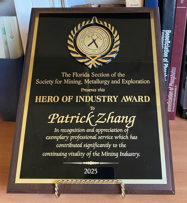 image of plaque with a seal and text: The Florida Section of the Society for Mining, Metallurgy and Exploration Presents this Hero of Industry Award to Patrick Zhang in recognition and appreciation of exemplary professional service which has contributed significantly to the continuing vitality of the Mining Industry, 2025