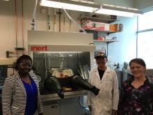 Three people standing in science laboratory