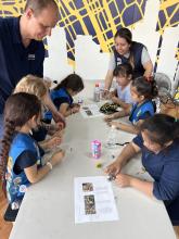 CMI Leadership Academy member Aaron Malone, Colorado School of Mines, shown top left, guides CMI magnet activity with youth in after-school program in Michigan.